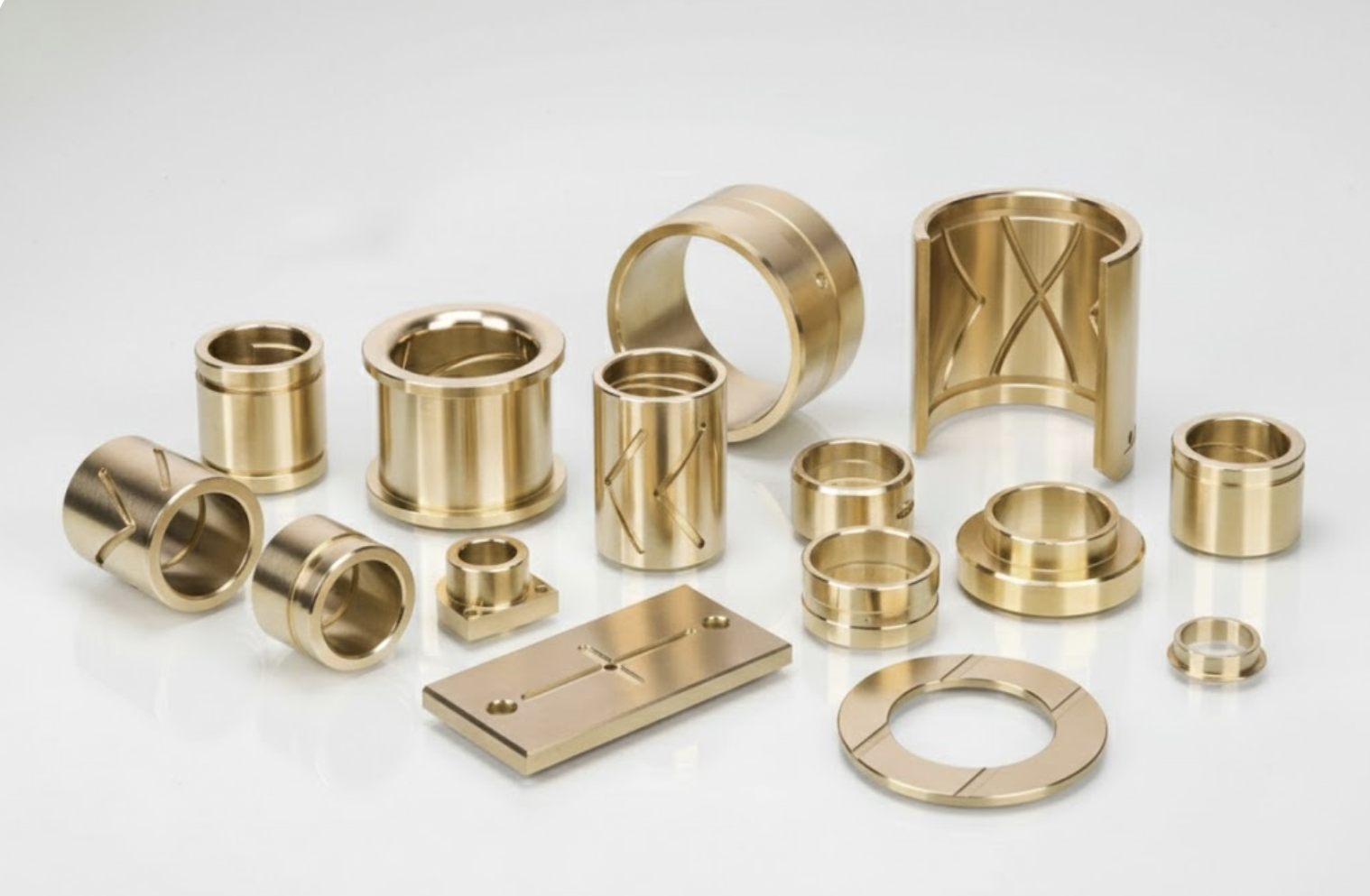 Wide collection of grooved aluminum bronze bushings featuring various lubrication patterns for heavy-duty industrial use.